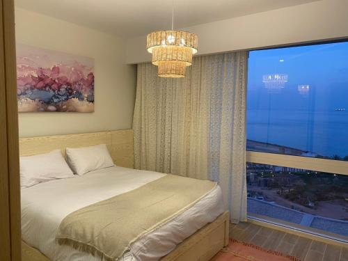 a bedroom with a bed and a large window at Il monte galala Sea view Chalet المونت جلاله in Ain Sokhna