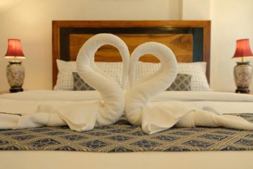 two towel swans are sitting on a bed at Villa Italia Hotel in Sorsogon