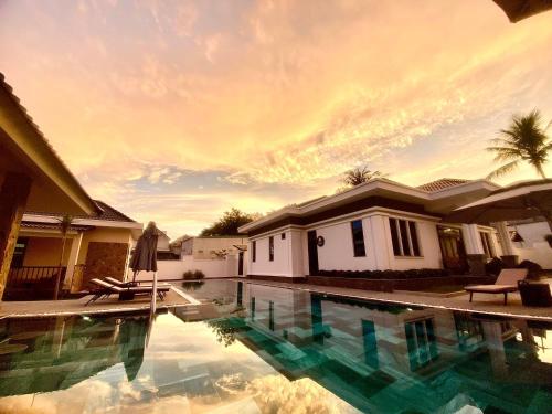 a swimming pool in front of a house at LAM BUNGALOW Resort & Spa in Phu Quoc