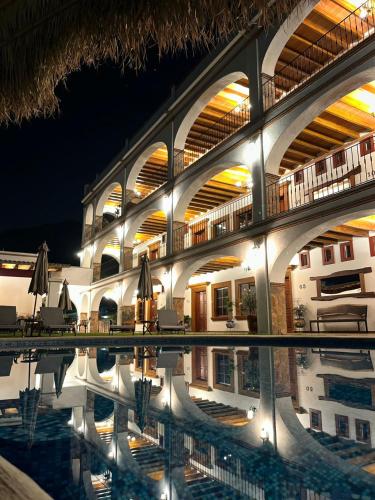 a large building with a swimming pool at night at Palacio Del Cobre in Tepoztlán