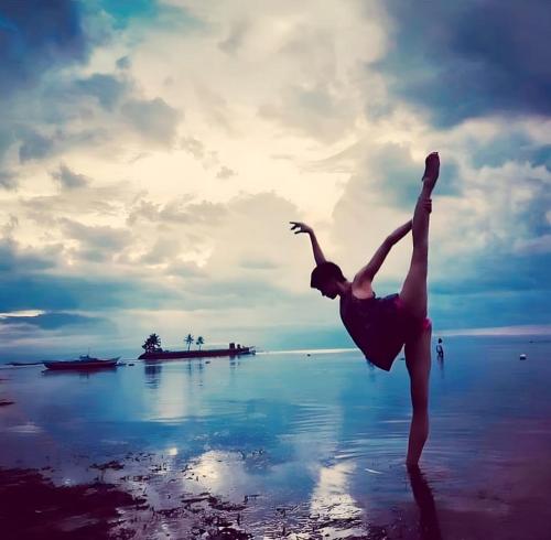 Una donna in piedi sulla spiaggia con le gambe in acqua di Blue Moon Inn a Dauis
