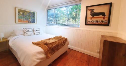 a bedroom with a bed and a window at Discover Booker Bay - Central Coast Family Getaway in Booker Bay