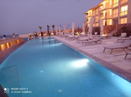 a large swimming pool with chairs and a building at Il monte galala Sea view Chalet المونت جلاله in Ain Sokhna