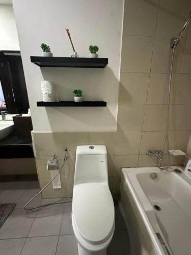 a bathroom with a toilet and a sink and a tub at Suites de Marina Manila with Netflix in Manila