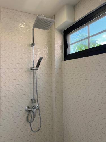 a shower stall in a bathroom with a window at Pink Villa by Tubtao Sleepy Hill in Pong Talong