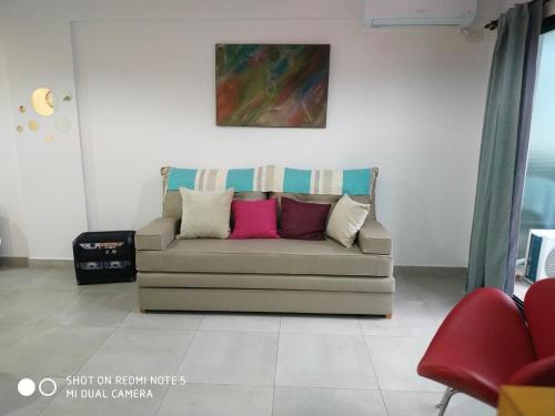 un sofá en una habitación con una pintura en la pared en Avellaneda UNO Apartment en Caballito en Buenos Aires