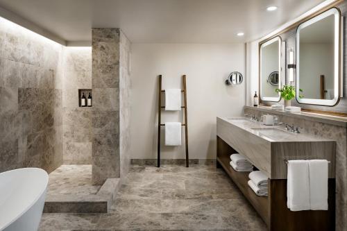 a bathroom with a tub shower and a sink at The Villas at Fairmont Kea Lani in Wailea