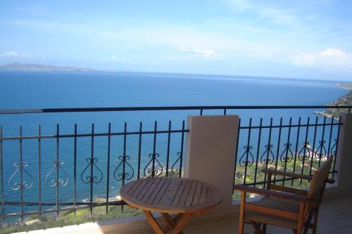 a balcony with a bench and a view of the ocean at Kleio Studios in Ravdhoúkha