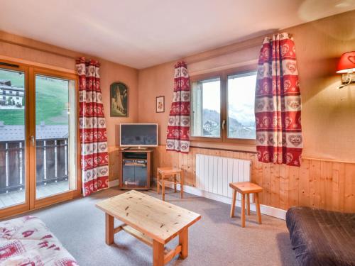 un salon avec un canapé et deux fenêtres dans l'établissement Appartement T2 idéalement situé entre les télécabines Mont Chéry et Chavannes, au cœur des Gets - FR-1-685-49, aux Gets