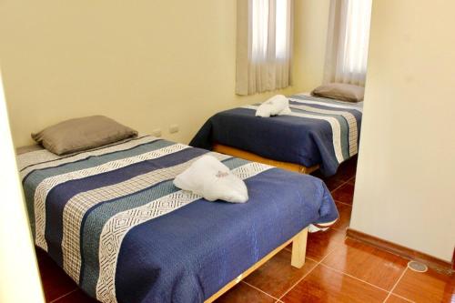 2 Betten mit Handtüchern auf einem Zimmer in der Unterkunft Chuklla in Yanque