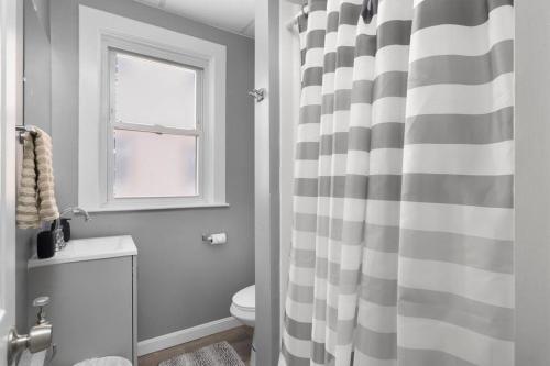 La salle de bains est pourvue d'un rideau de douche noir et blanc. dans l'établissement Modern 2 Bedroom in Downtown Providence., à Providence