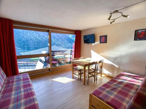 Cette chambre d'hôtel dispose d'une table et d'une grande fenêtre. dans l'établissement Studio confortable et lumineux à Tignes Le Lac, au pied des pistes, proche commerces, balcon sud - FR-1-502-423, à Tignes