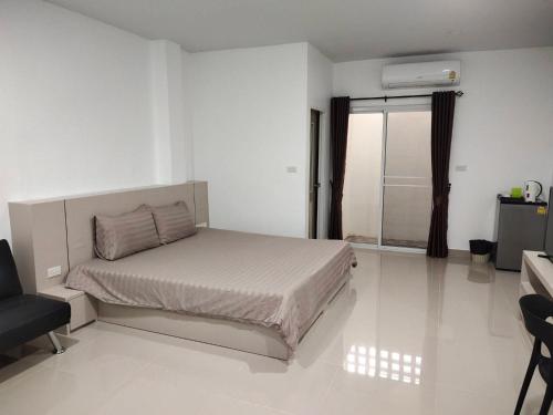 HADA House Service Apartment في بانكوك: غرفة نوم بيضاء بها سرير ونافذة