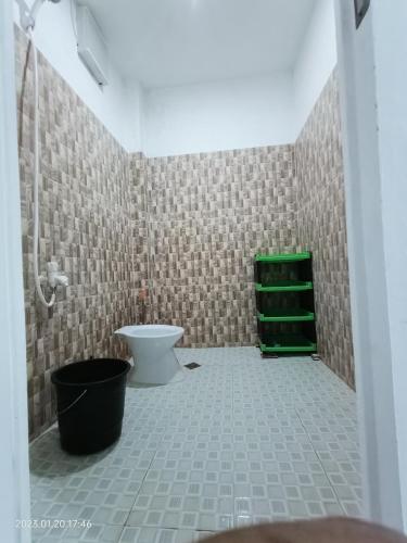 a bathroom with a toilet and a green shelf at Chief's Villa Extension in Malapascua Island