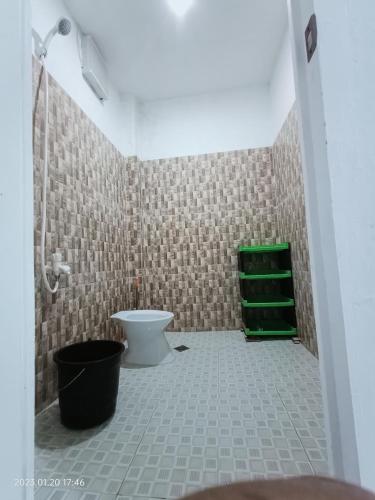 a bathroom with a toilet and a green shelf at Chief's Villa Extension in Malapascua Island