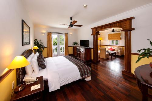 Habitación de hotel con cama y sala de estar. en Victoria Can Tho Resort, en Can Tho
