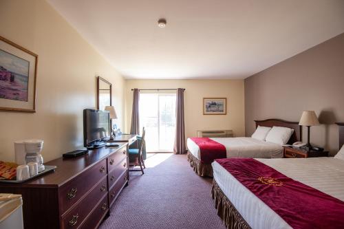 a hotel room with two beds and a television at Cavendish Memotree Resort in Cavendish