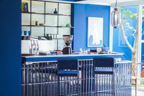 a blue bar with blue walls and blue chairs at KRAAM Silhouette Hotel and Cafe Phuket in Chalong 