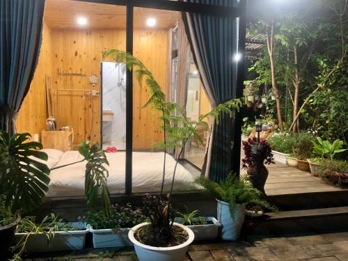 a room with a bed and a bunch of plants at Bắp's House Đà Lạt in Da Lat
