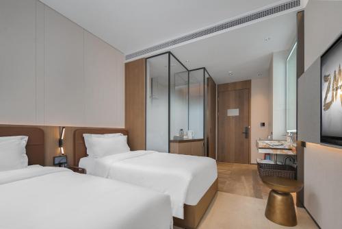 a hotel room with two beds and a mirror at ZMAXHOTELS - Guangzhou TaiKoo Hui - Complimentary Craft Beer - Metro Line 3 Directly to Canton Fair Venue in Guangzhou