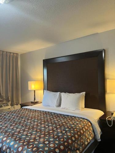 a large bed with a large headboard in a hotel room at Goldstar Inn in Los Angeles