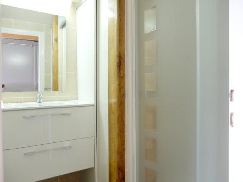 une salle de bain blanche avec un lavabo et un miroir dans l'établissement Studio Confortable et Moderne avec Balcon - Pied des Pistes et Proche Commerces - FR-1-502-460, à Tignes