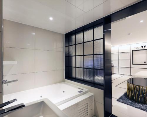 a white bathroom with a sink and a window at Mari Hotel in Cheongju