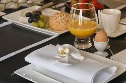 a table with plates of food and a glass of orange juice at B&B Colombe Blanche in Knokke-Heist