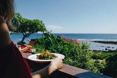a woman sitting at a table with a bowl of salad at White Grass Ocean Resort & Spa in Tanna Island