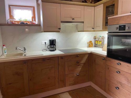 a kitchen with wooden cabinets and a sink at Holiday home in Drganja sela Kranjska Krain 42002 in Drganja Sela