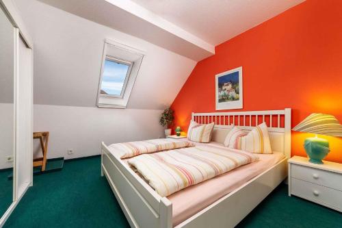 a bedroom with a bed with an orange wall at House and Apt in Balatonboglar 42692 in Balatonboglár