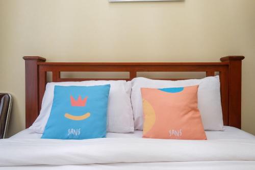 two pillows sitting on top of a bed at Sans Hotel Kumbang Yogyakarta by RedDoorz in Yogyakarta