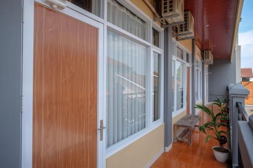 an empty balcony with a wooden door and windows at Sans Hotel Kumbang Yogyakarta by RedDoorz in Yogyakarta