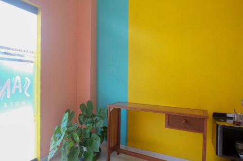 a room with colorful walls and a table and a plant at Sans Hotel Kumbang Yogyakarta by RedDoorz in Yogyakarta