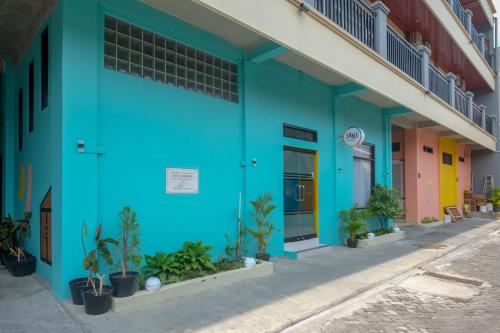 a blue building with plants in front of it at Sans Hotel Kumbang Yogyakarta by RedDoorz in Yogyakarta