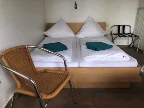 uma cama com duas almofadas verdes e uma cadeira em Houses and Apts in Sassenburg Niedersachsen 42038 em Sassenburg