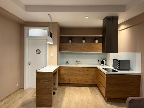 una cocina con armarios de madera y fregadero en City Center Apartment, en Katowice