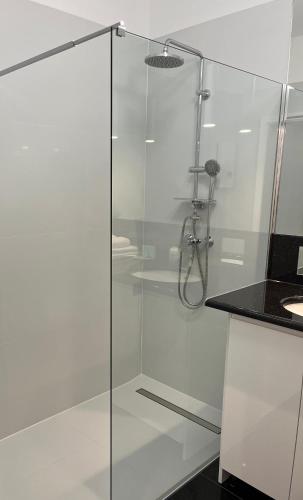 a shower with a glass door in a bathroom at City Center Apartment in Katowice