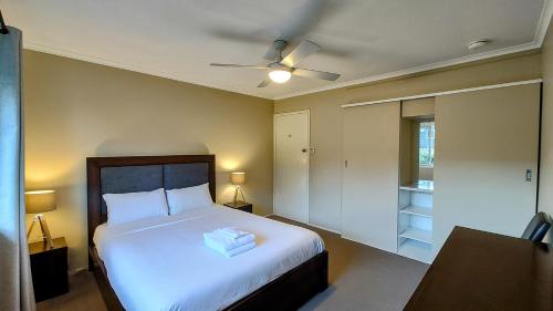 a bedroom with a bed and a ceiling fan at 5 min walk to City Center in Toowoomba