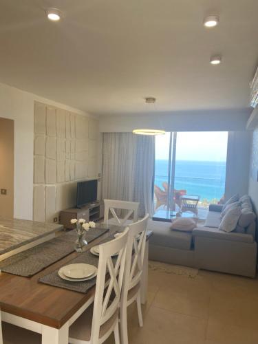 a dining room and living room with a view of the ocean at Il Monte Galala Ain sokhna - المونت جلاله in Ain Sokhna