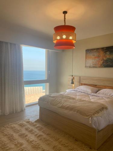 um quarto com uma cama grande e uma janela grande em Sea view il monte galala chalet em Ain Sokhna