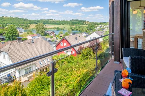 a balcony with a view of a town at Ferienwohnung Seeblick in Schalkenmehren