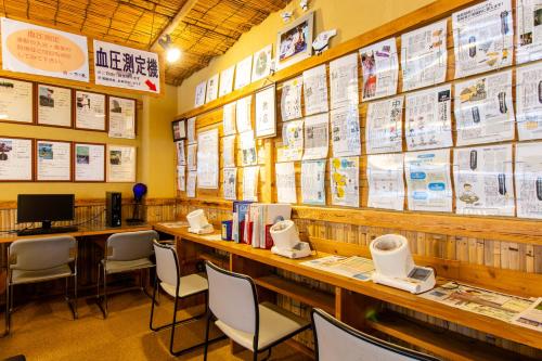 a restaurant with tables and chairs and posters on the wall at Oyado Hisaya in Kami