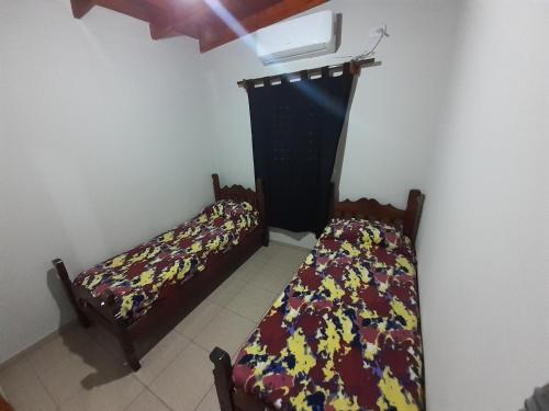a bedroom with two beds in a room with a window at Hospédate en Nuestra Cabaña en Termas de Rio Hondo y Disfruta de unas Confortables y Relajantes Vacaciones in Termas de Río Hondo