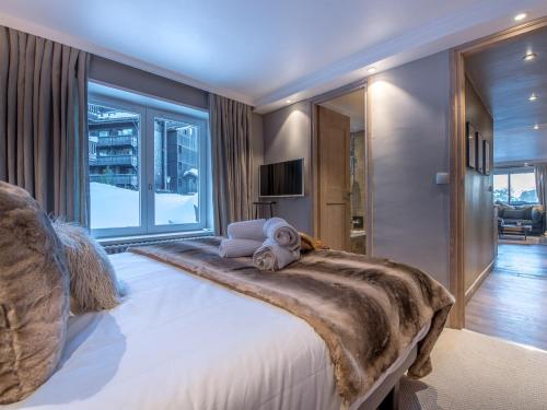 a bedroom with a large bed with a large window at Appartement Neuf et Luxueux Centre Courchevel 1850, Proche Pistes et Services - FR-1-575-160 in Courchevel