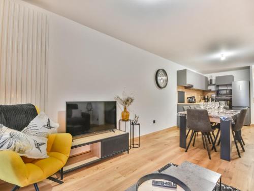 un salon avec une télévision et une table avec des chaises dans l'établissement Appartement moderne T3 - Proche pistes et village - 6 pers - Parking - Ski room - Wifi - FR-1-685-65, aux Gets