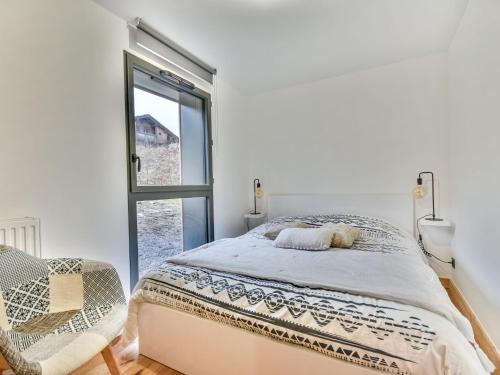 a white bedroom with a bed and a window at Appartement Les Gets, 3 pièces, 6 personnes - FR-1-685-65 in Les Gets