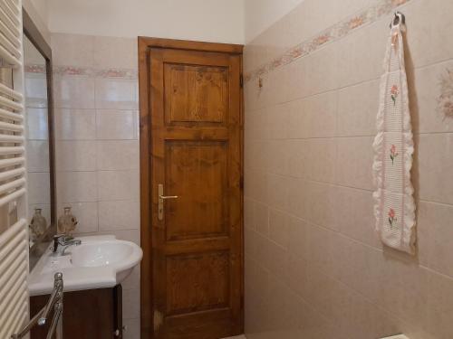 La salle de bains est pourvue d'un lavabo et d'une porte en bois. dans l'établissement Casa Fiorina, à Barga
