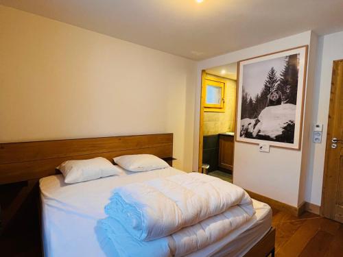 1 dormitorio con 1 cama grande con sábanas blancas en Appartement Les Saisies, 3 pièces, 6 personnes - FR-1-293-376, en Hauteluce