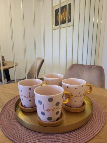 four coffee cups sitting on a tray on a table at Tonka studio apartman in Križevci